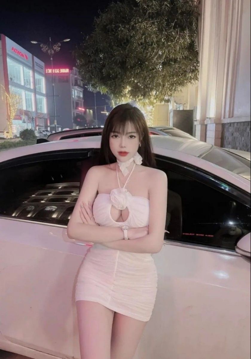 Gái Trẻ Mặc Áo Đầm Trắng Ôm Sát Dựa Vào Xe Hơi