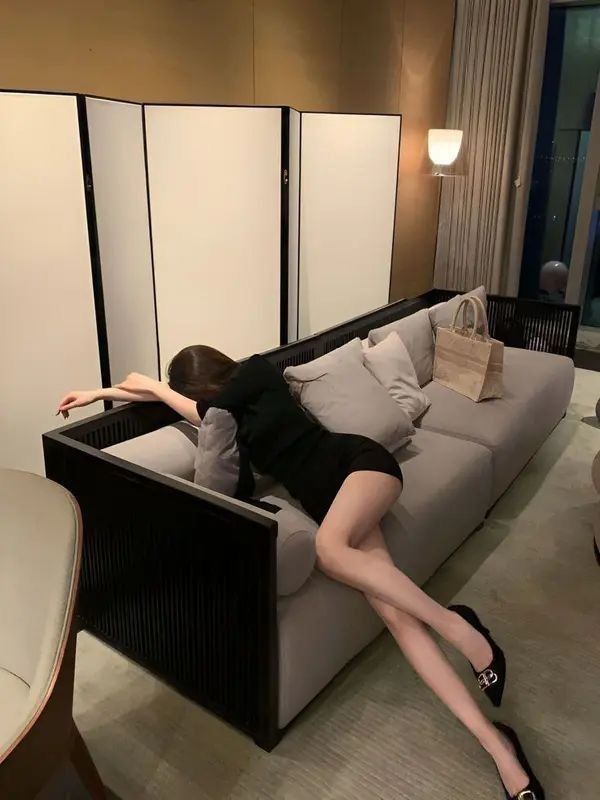 Gái Trẻ Mặc Áo Đen Và Shorts Ngồi Thư Giãn Trên Sofa Sang Trọng