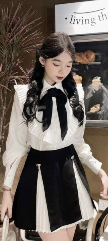 Ảnh cô gái mặc áo sơ mi trắng, chân váy đen xếp ly thời thượng