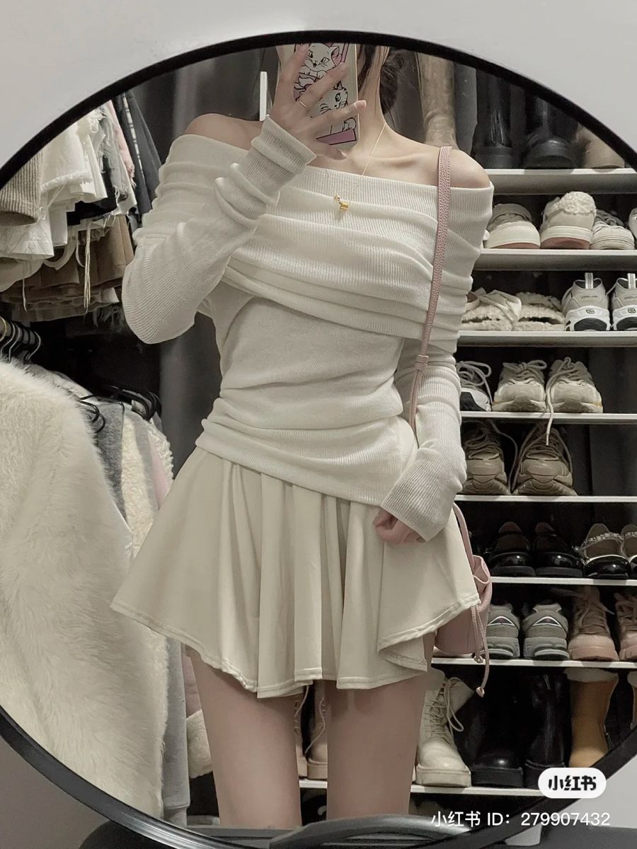 Ảnh cô gái mặc áo sweater trắng xếp chéo và chân váy ngắn màu kèm