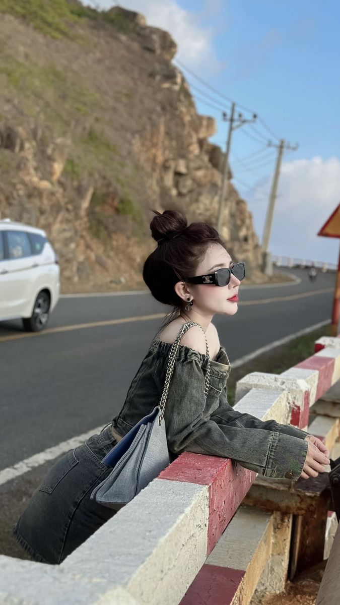 Ảnh cô gái trẻ mặc áo denim phom rộng bên cầu