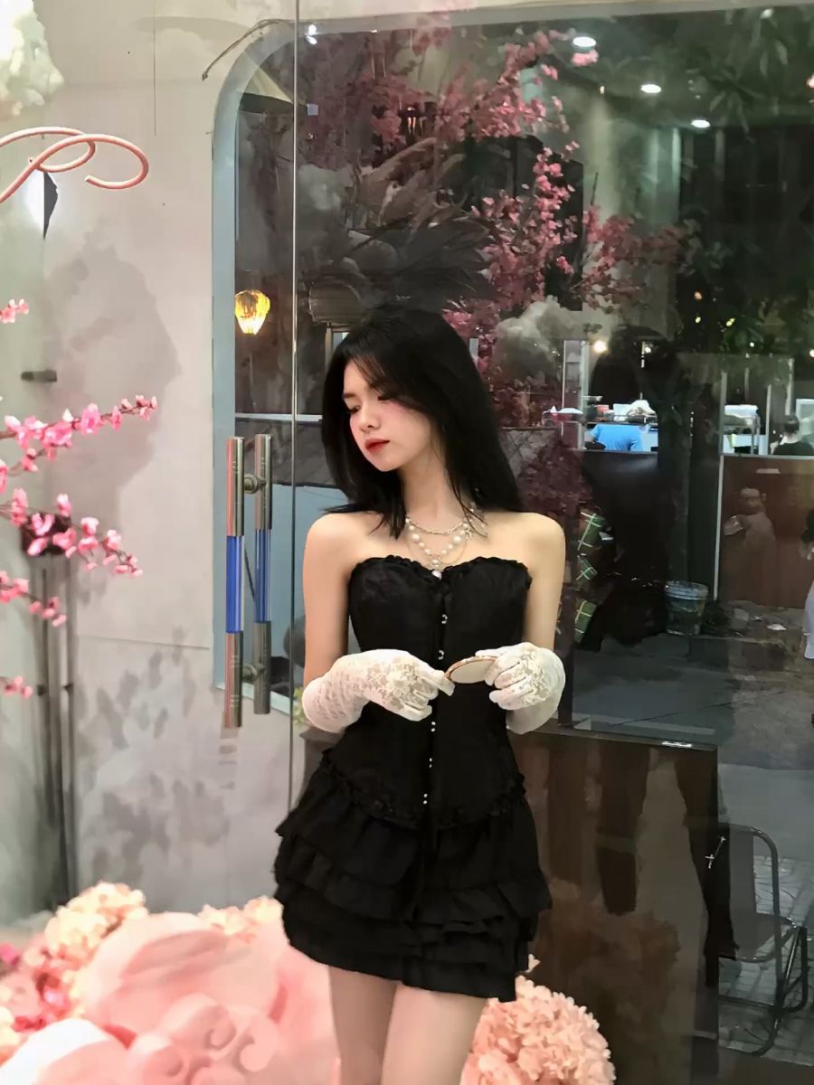 Ảnh gái diện váy đen ruffled, tay trắng tạo dáng bên cửa kính