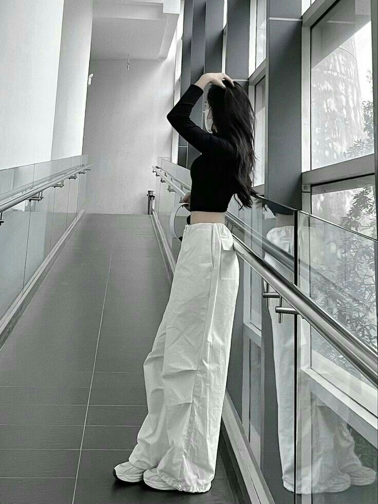 Ảnh gái mặc áo crop top đen và quần trắng trong hành lang sang trọng