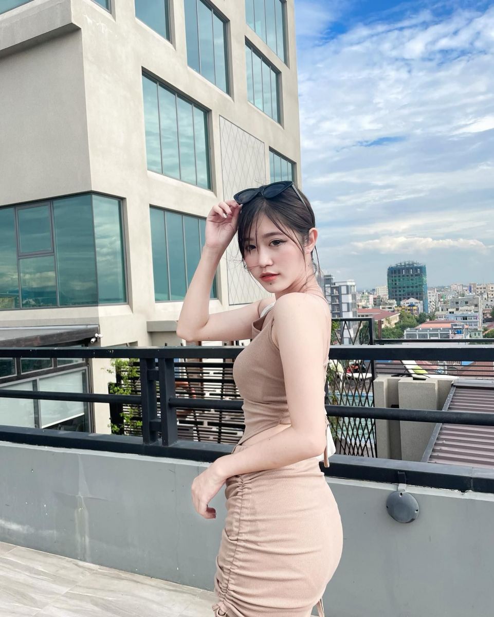 Ảnh gái mặc đầm ôm màu be trên ban công cao tầng