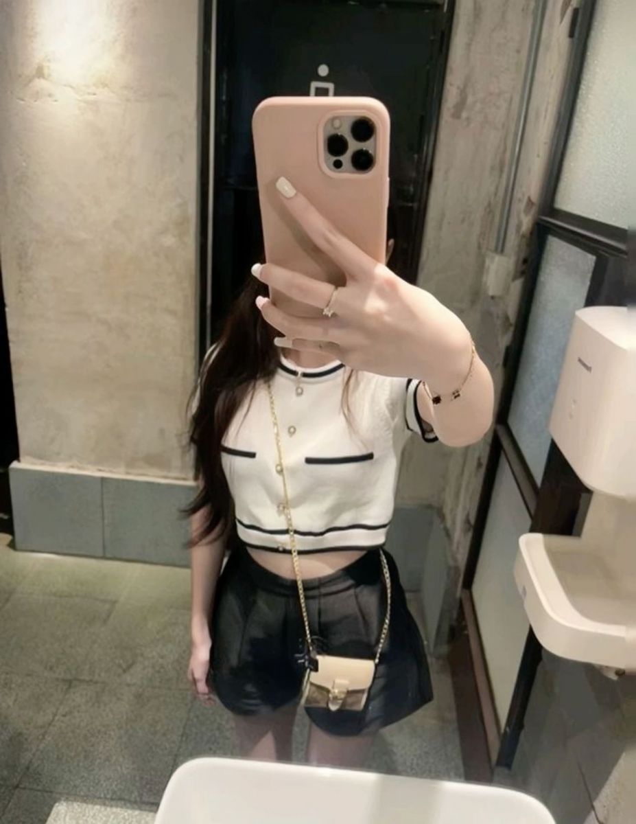 Ảnh gái trẻ mặc áo crop top trắng và chân váy đen