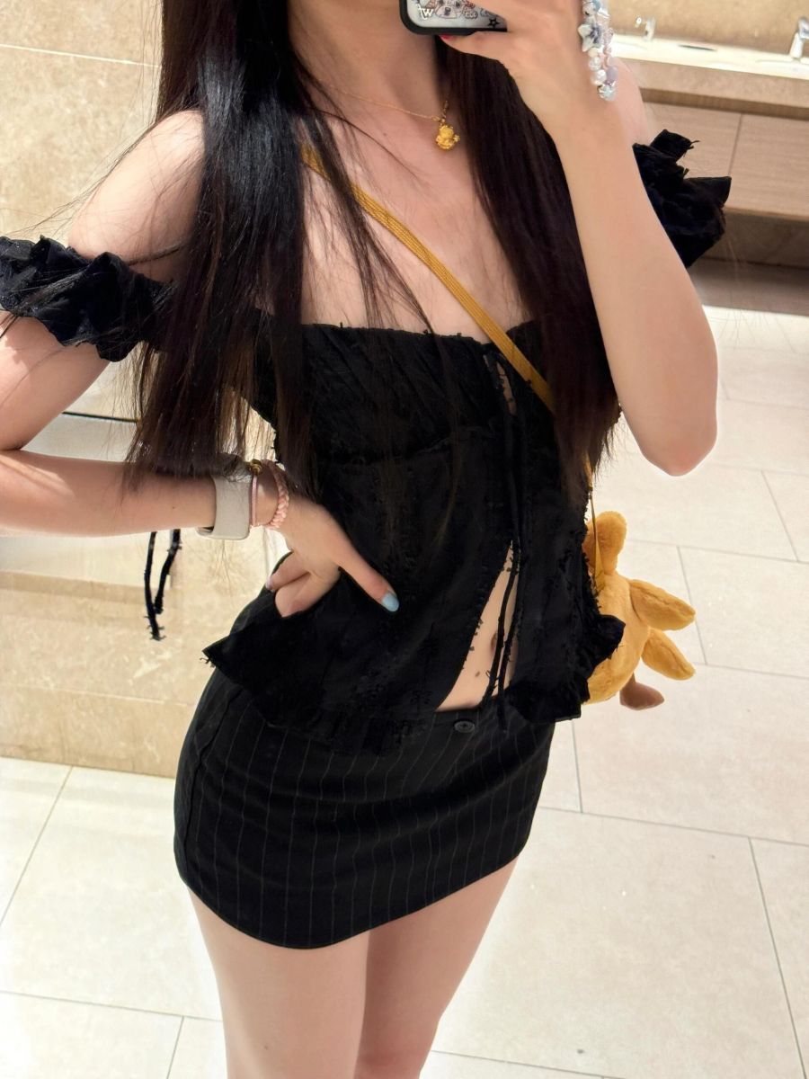 Ảnh gái trẻ mặc áo croptop đen và chân váy ngắn trong phòng tắm
