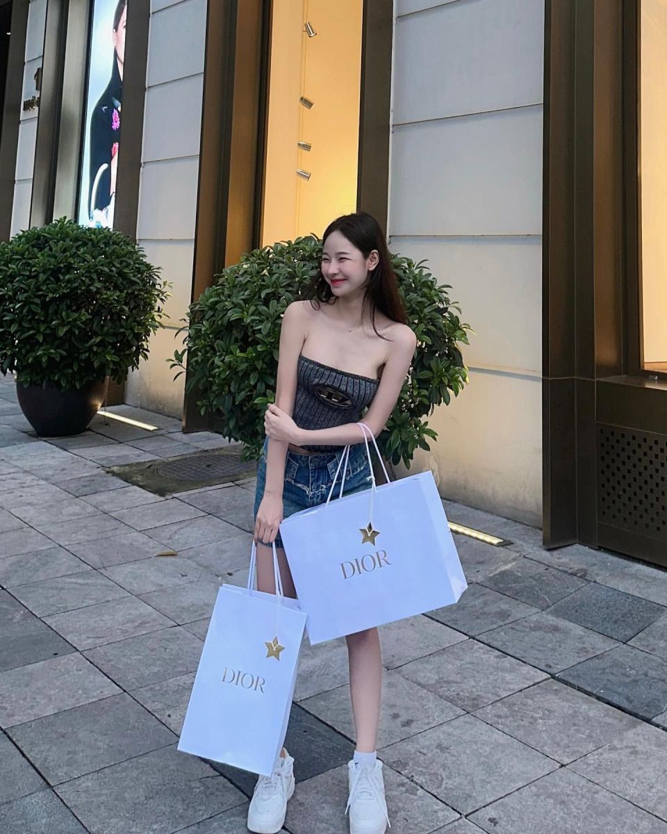 Ảnh gái trẻ mặc áo croptop và váy jeans tại cửa hàng thời trang Dior