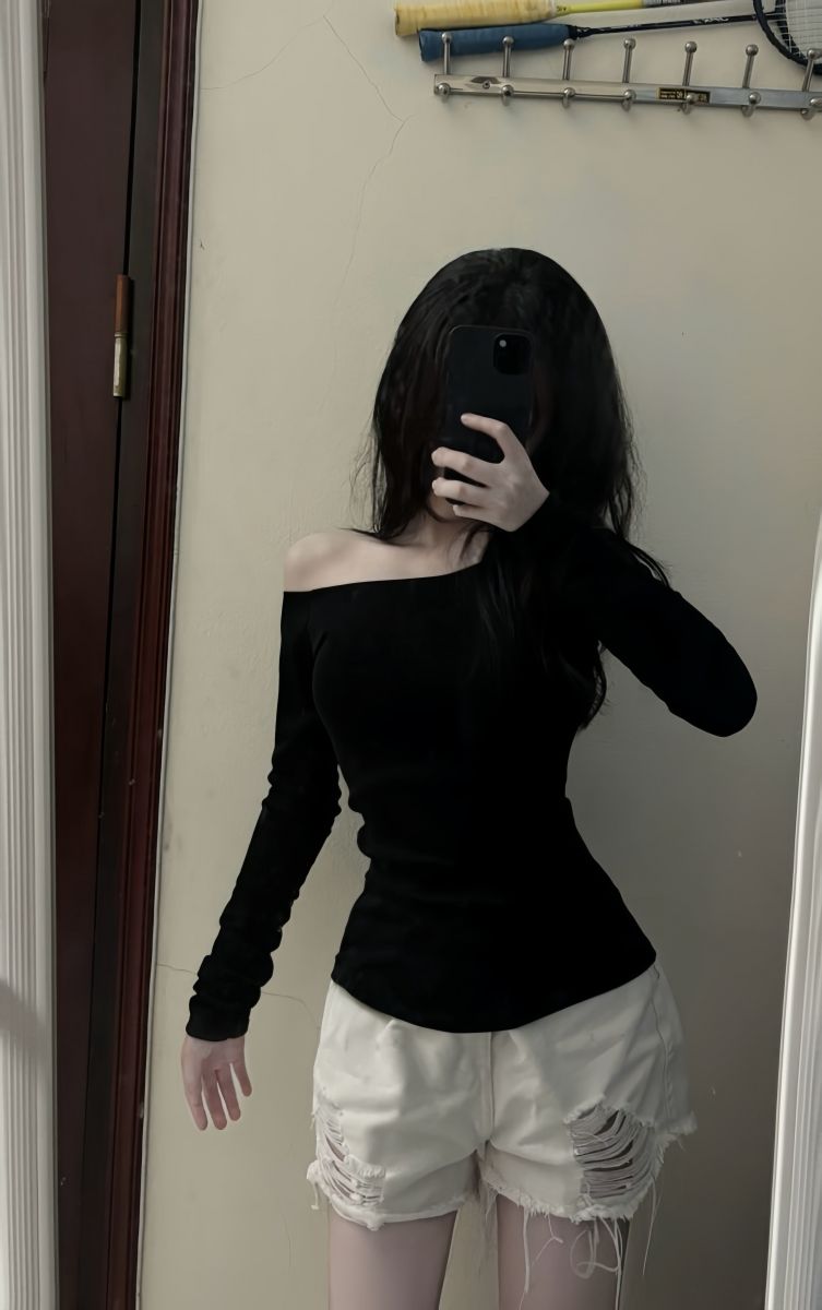 Ảnh gái trẻ mặc áo dài tay màu đen và quần shorts trắng