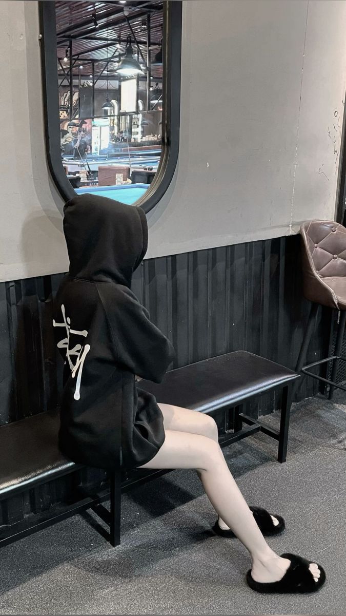 Ảnh gái trẻ mặc áo hoodie đen ngồi trong quán cà phê
