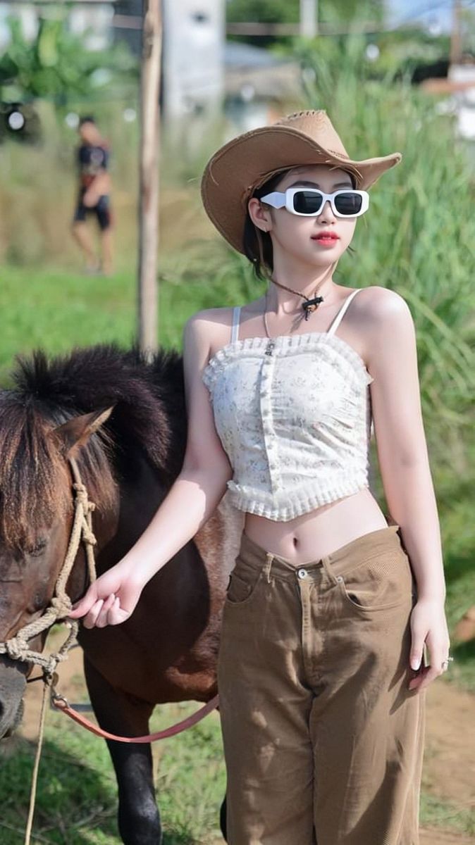 Ảnh gái trẻ mặc áo ống và quần dài tại vùng quê xanh tươi