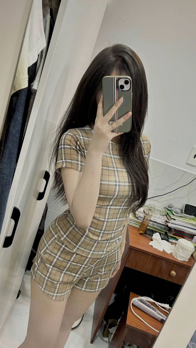 Ảnh gái trẻ mặc áo thun kẻ caro màu nâu chụp selfie trong gương