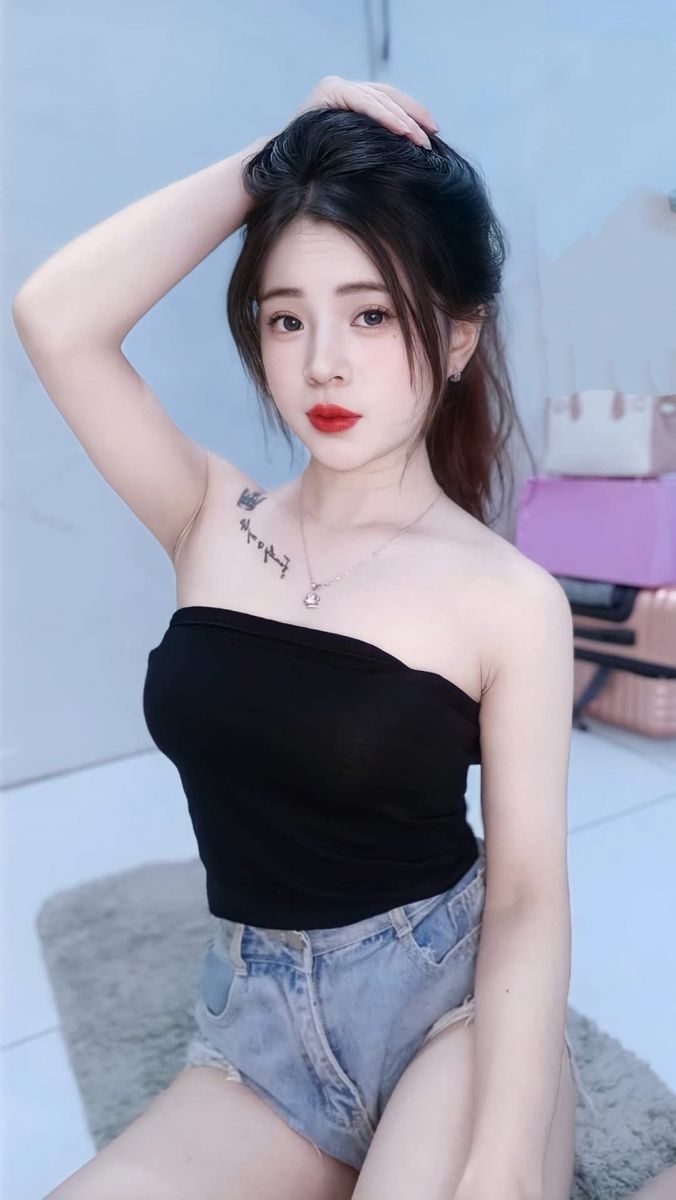 Ảnh gái trẻ mặc áo top màu đen và quần jeans ngắn
