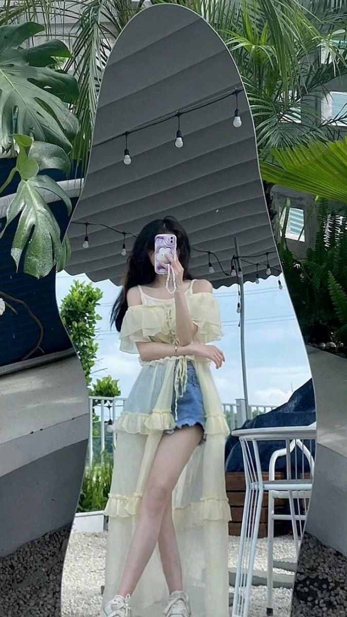 Ảnh gái trẻ mặc áo voan vàng và quần denim ngắn
