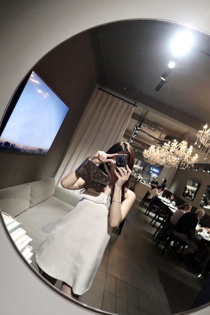 Ảnh gái trẻ mặc đầm trắng chụp selfie trong nhà hàng sang trọng