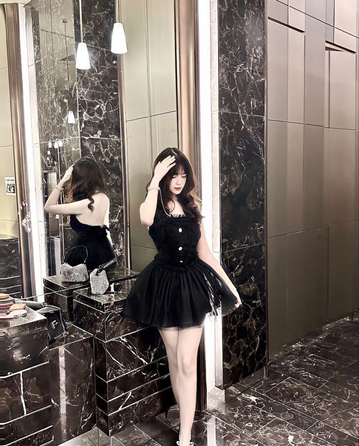 Ảnh gái xinh mặc váy đen ngắn tạo dáng trước gương