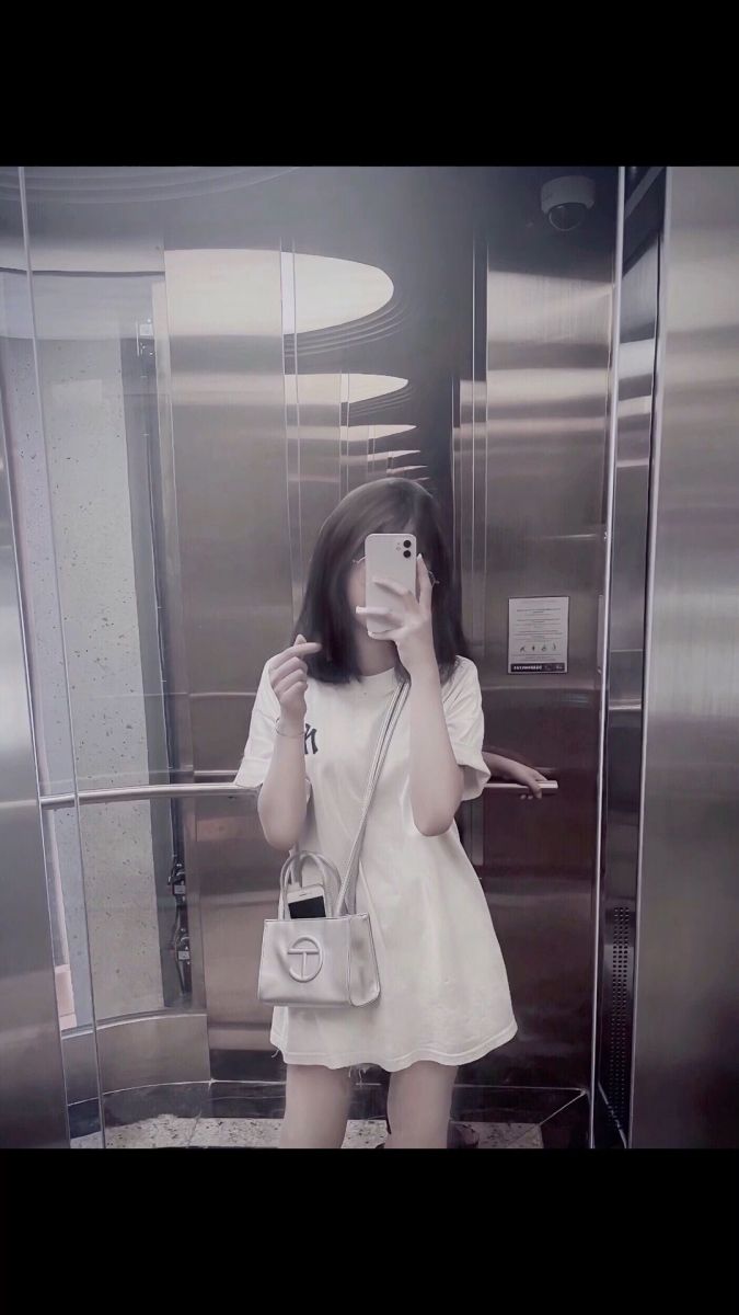 Bộ ảnh gái xinh trong thang máy với áo trắng tay cầm hạt heart