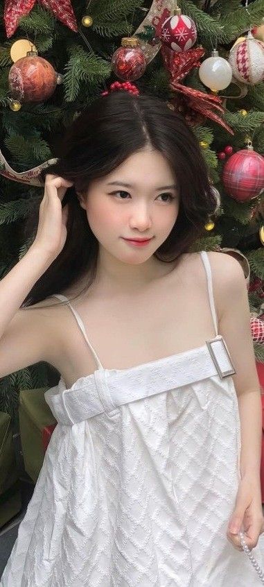 Chiếc váy trắng nhẹ nhàng của cô gái bên cây thông Noel