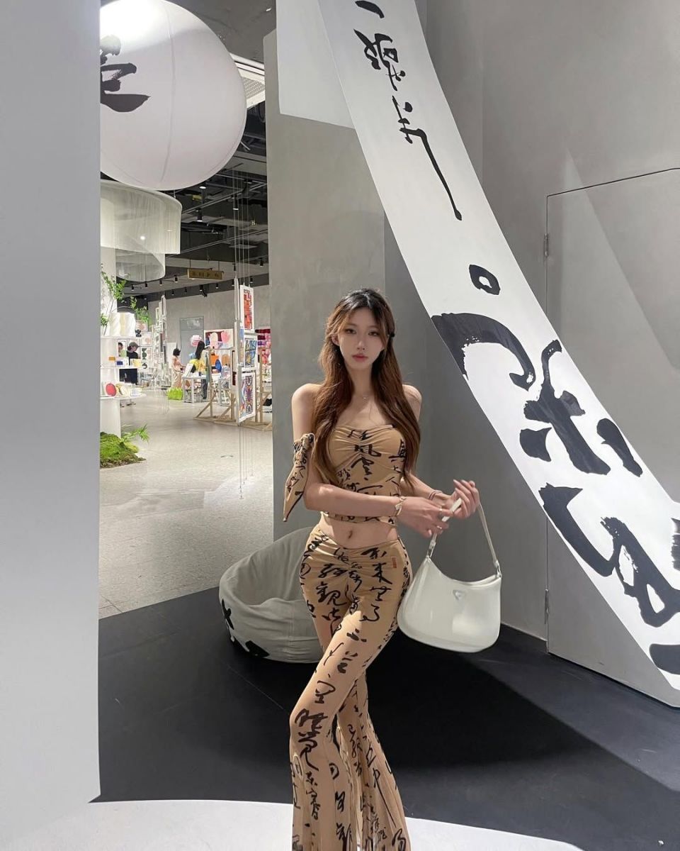 Cô gái đẹp mặc váy bố sát màu nâu với họa tiết chữ