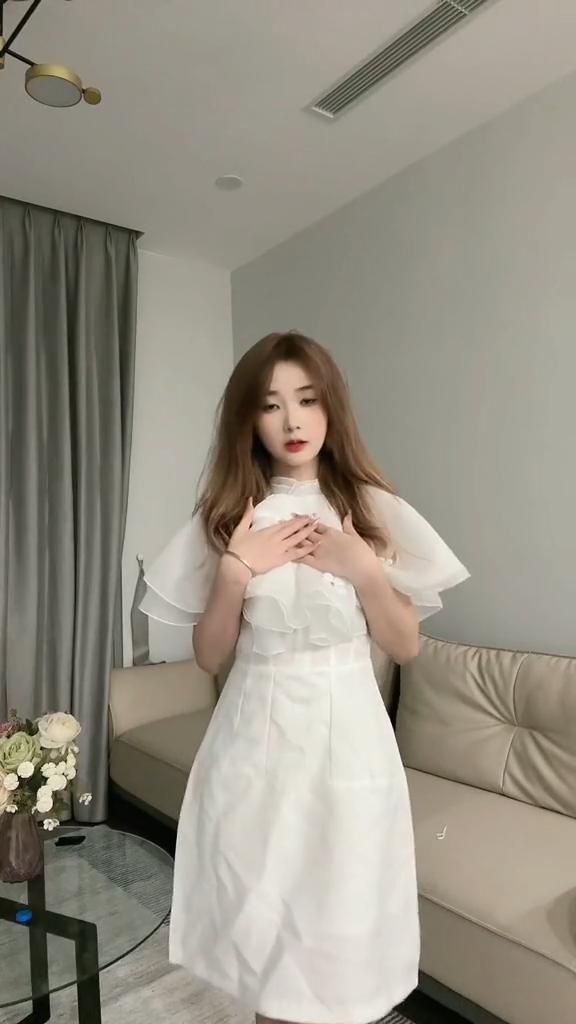 Cô gái đẹp mặc váy trắng duyên dáng trong phòng khách