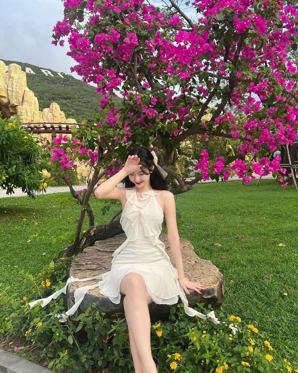 Cô gái đẹp mặc váy trắng giữa khu vườn hoa rực rỡ
