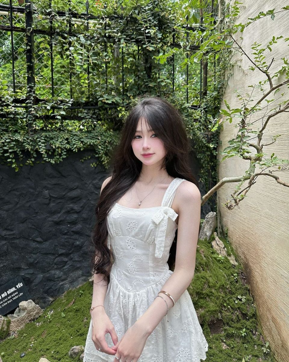 Cô gái đẹp mặc váy trắng giữa khu vườn xanh tươi