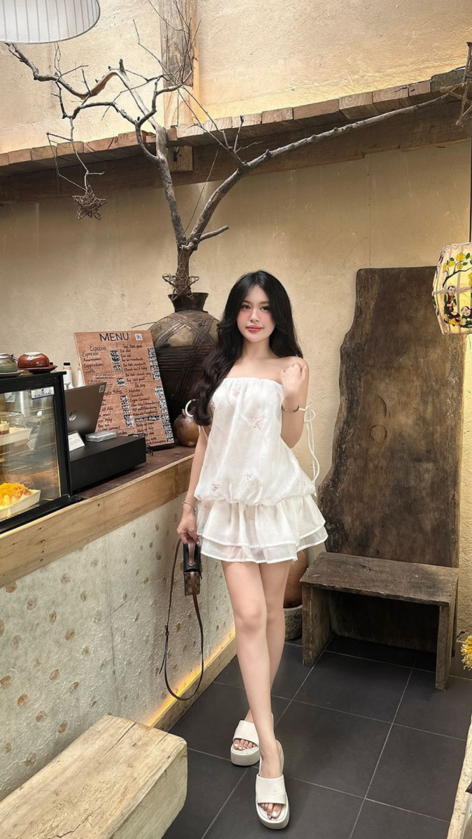 Cô gái đẹp mặc váy trắng trong quán cà phê ấm cúng