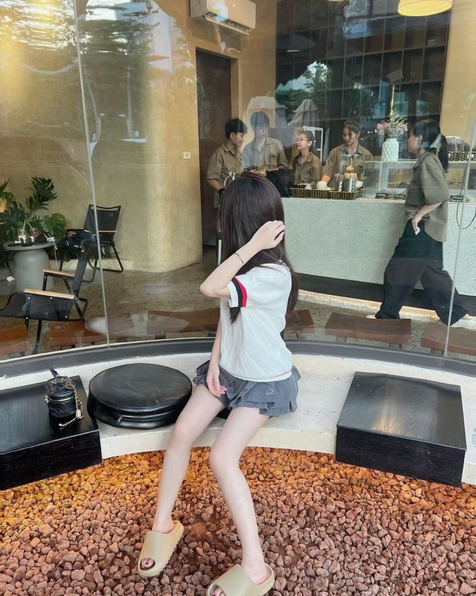Cô gái đẹp trong áo phông trắng và chân váy xám
