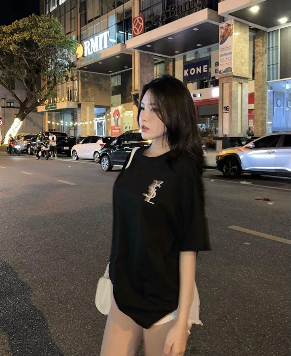 Cô gái mặc áo phông đen và quần shorts tự tin trên phố