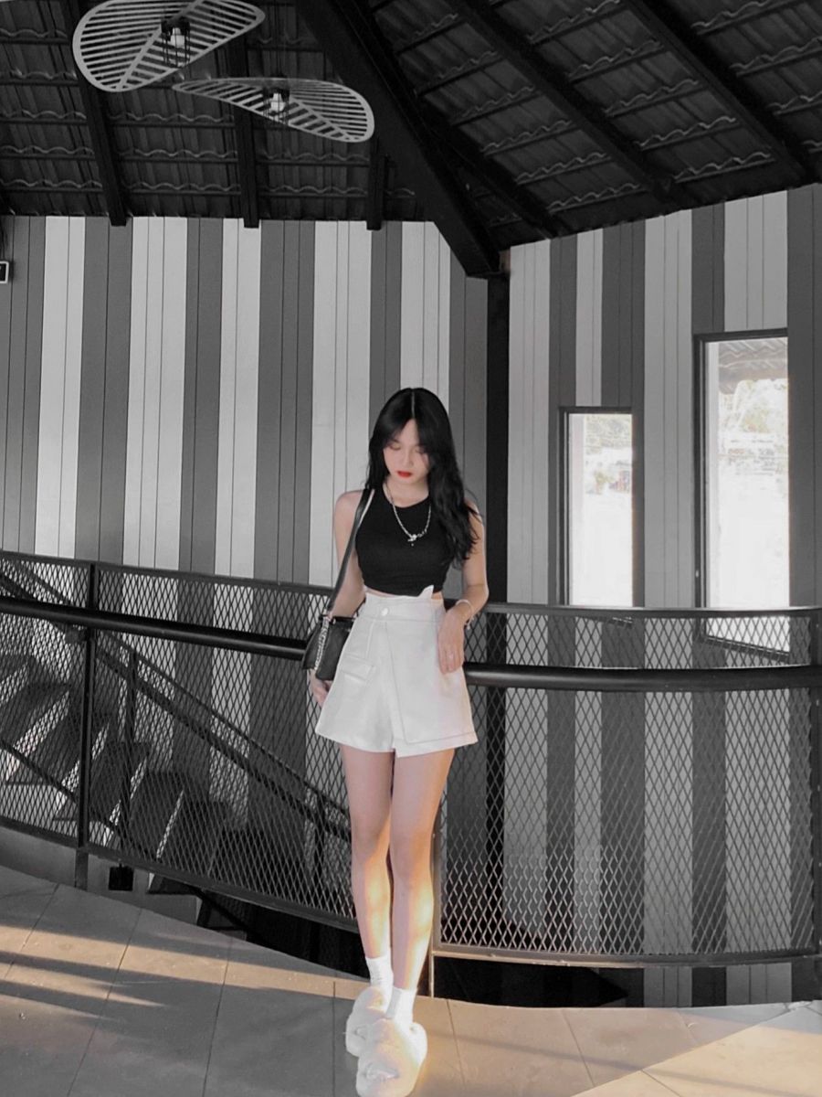 Cô gái mặc áo sát nách đen và quần shorts trắng ấn tượng