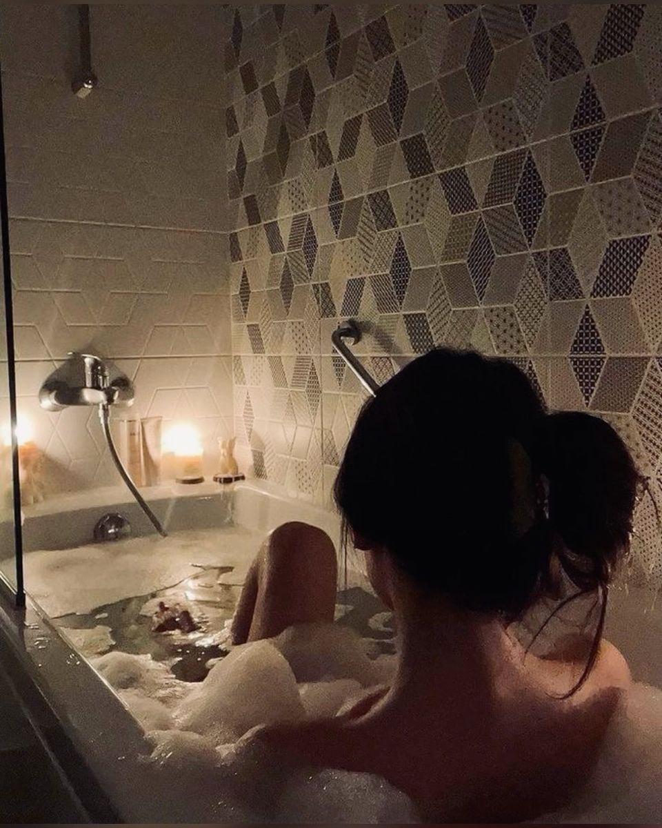 Cô gái mặc áo tắm trong bồn tắm nhìn về phía trước