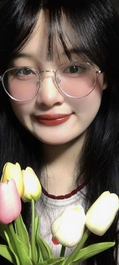 Cô gái mặc áo thun trắng cổ viền đỏ cam bên hoa tulip rực rỡ