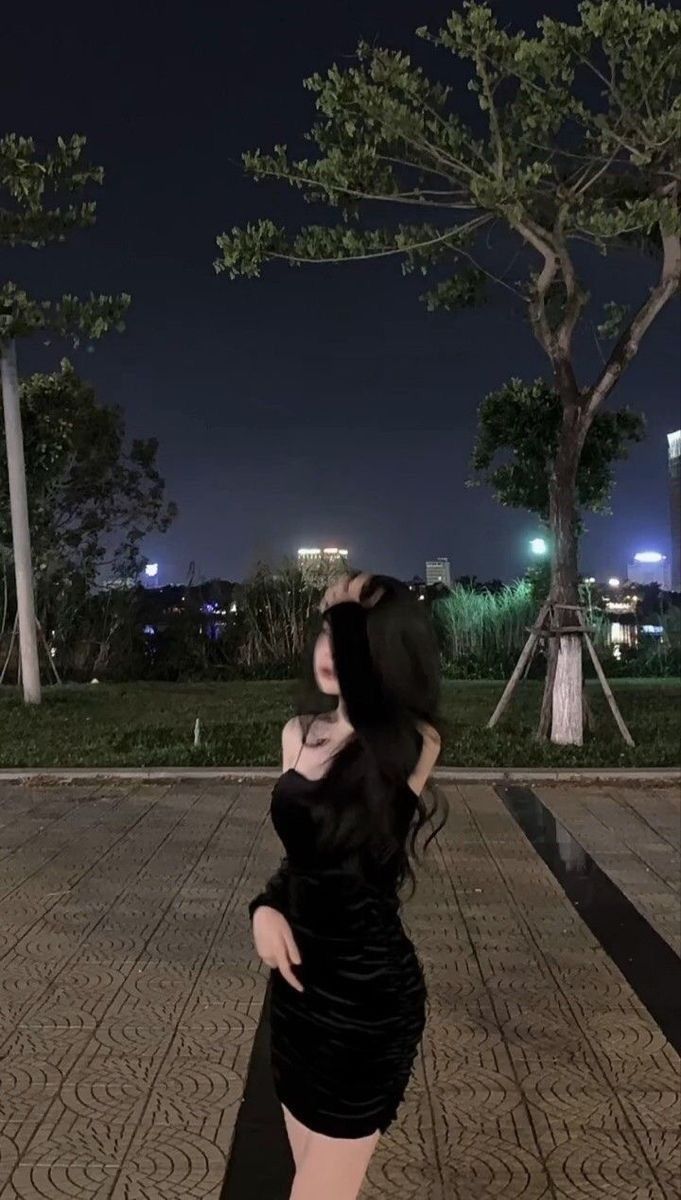 Cô gái mặc đầm đen tự tin bên ngoài vào ban đêm