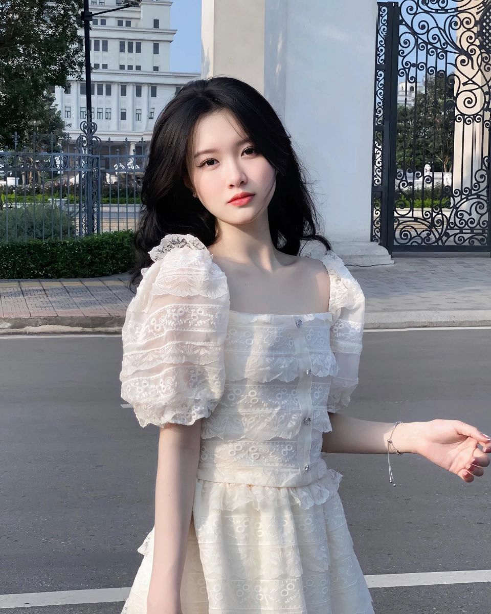 Cô gái mặc đầm trắng phong cách vintage trên vỉa hè