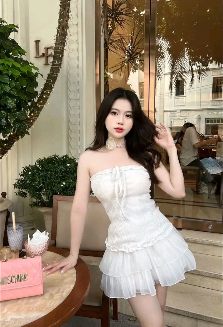 Cô gái mặc đồ trắng chụp ảnh trong quán cà phê sáng tạo