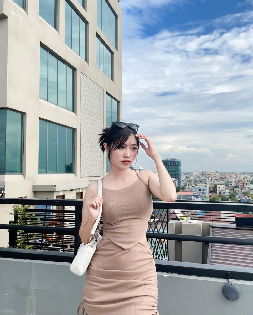 Cô gái mặc váy ôm màu be trên tầng thượng