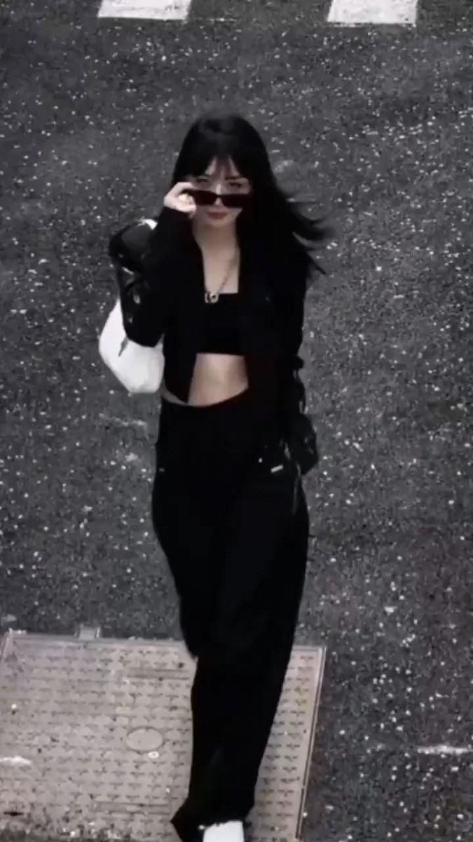 Cô gái trẻ diện áo crop top đen và quần rộng trên phố