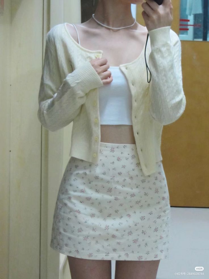 Cô gái trẻ mặc áo cardigan màu kem và áo crop top trắng