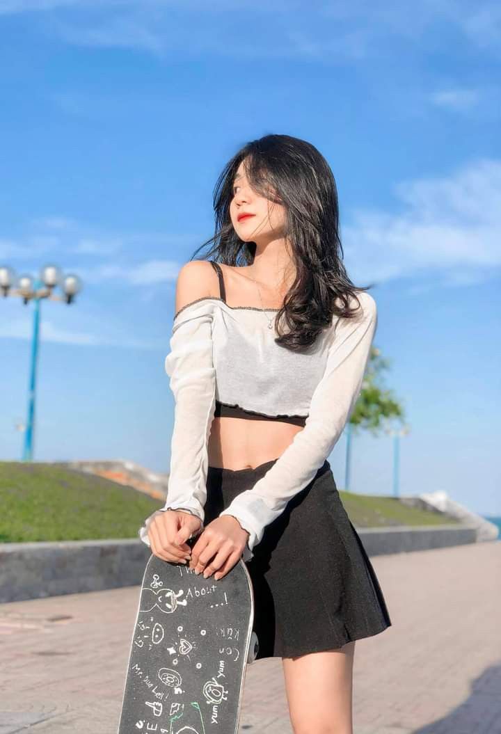 Cô gái trẻ mặc áo crop top trắng và đen kết hợp với chân váy ngắn