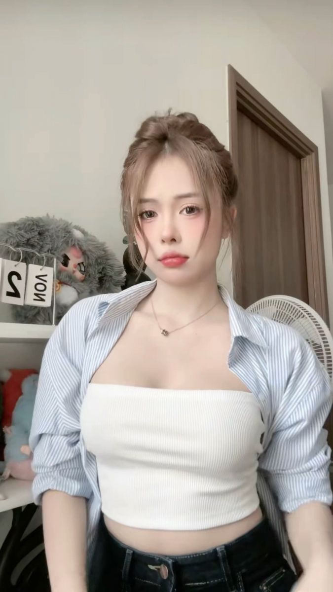 Cô gái trẻ mặc áo crop top trắng và sơ mi sọc phong cách mùa thu