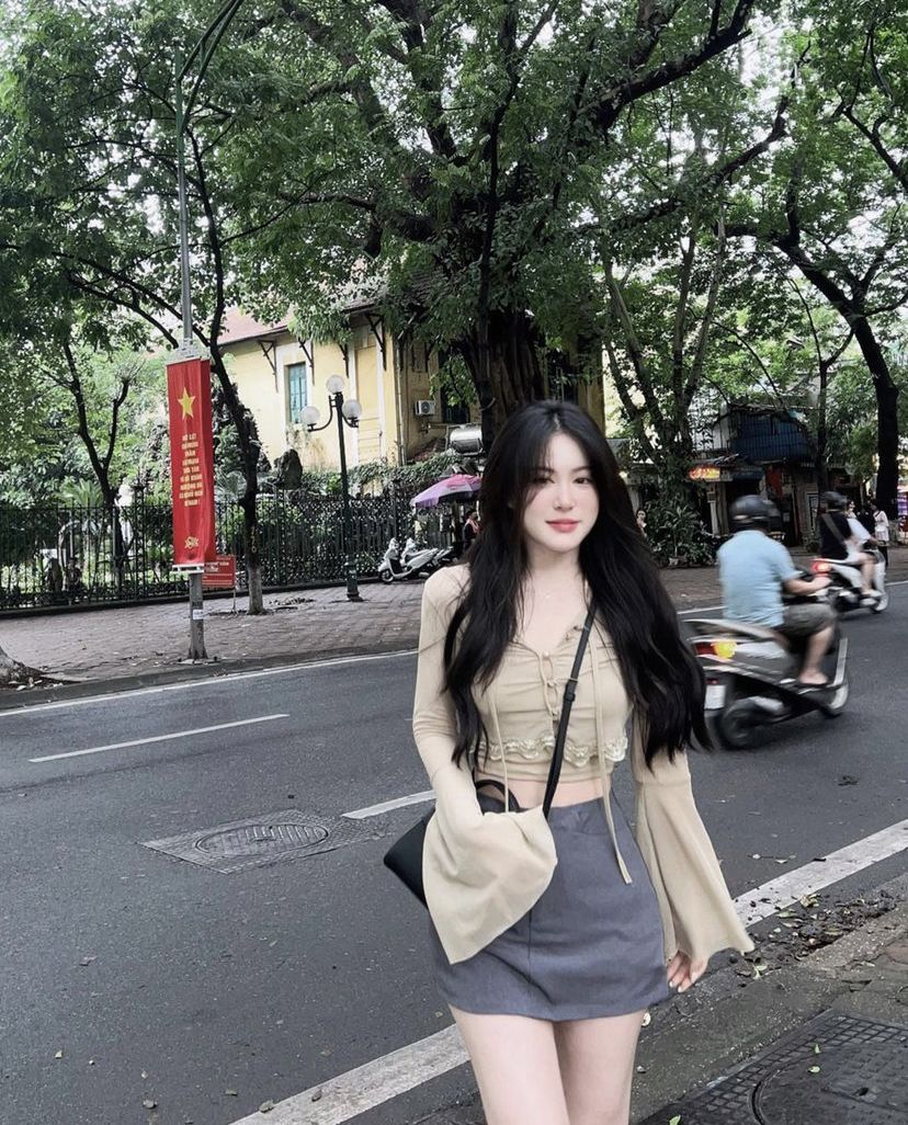 Cô gái trẻ mặc áo crop top và chân váy ngắn trên vỉa hè
