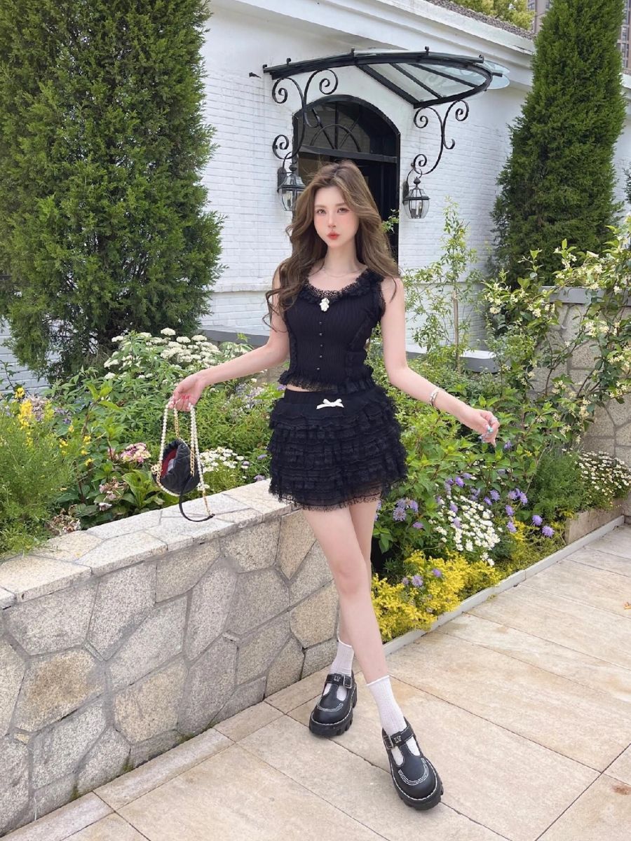 Cô gái trẻ mặc áo crop top và chân váy xòe đen ruffled