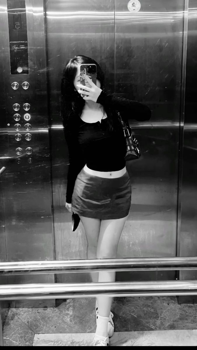 Cô gái trẻ mặc áo croptop đen và chân váy ngắn đầy quyến rũ