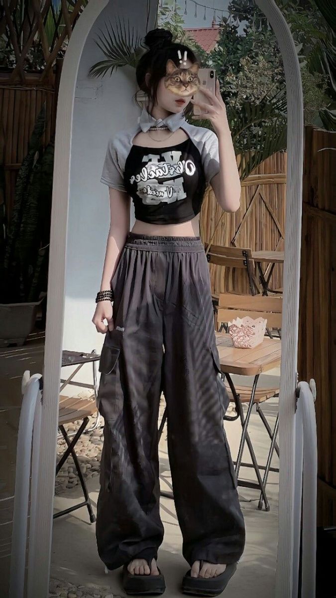 Cô gái trẻ mặc áo croptop đen và quần baggy màu đen