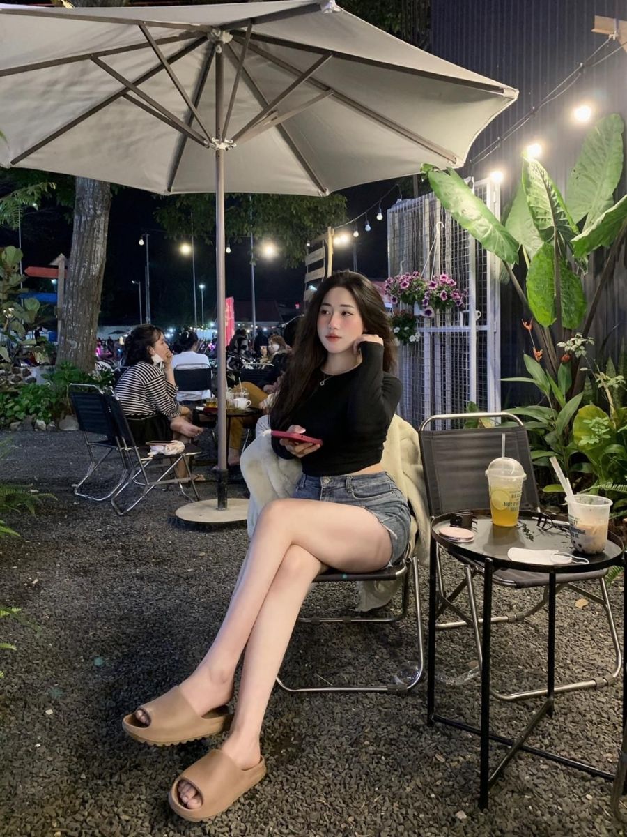 Cô gái trẻ mặc áo dài tay đen và quần shorts jeans