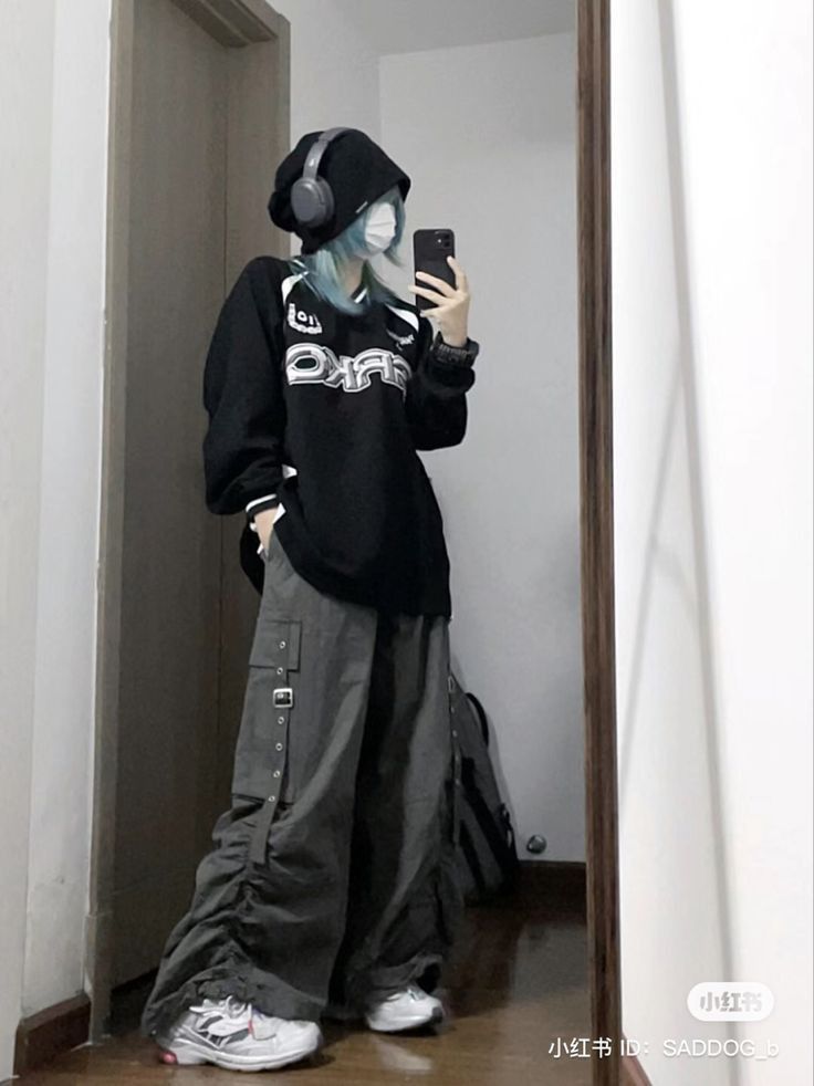 Cô gái trẻ mặc áo hoodie đen và quần rộng màu xám