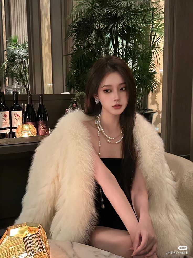 Cô gái trẻ mặc áo khoác trắng và váy đen tại quán bar sang trọng