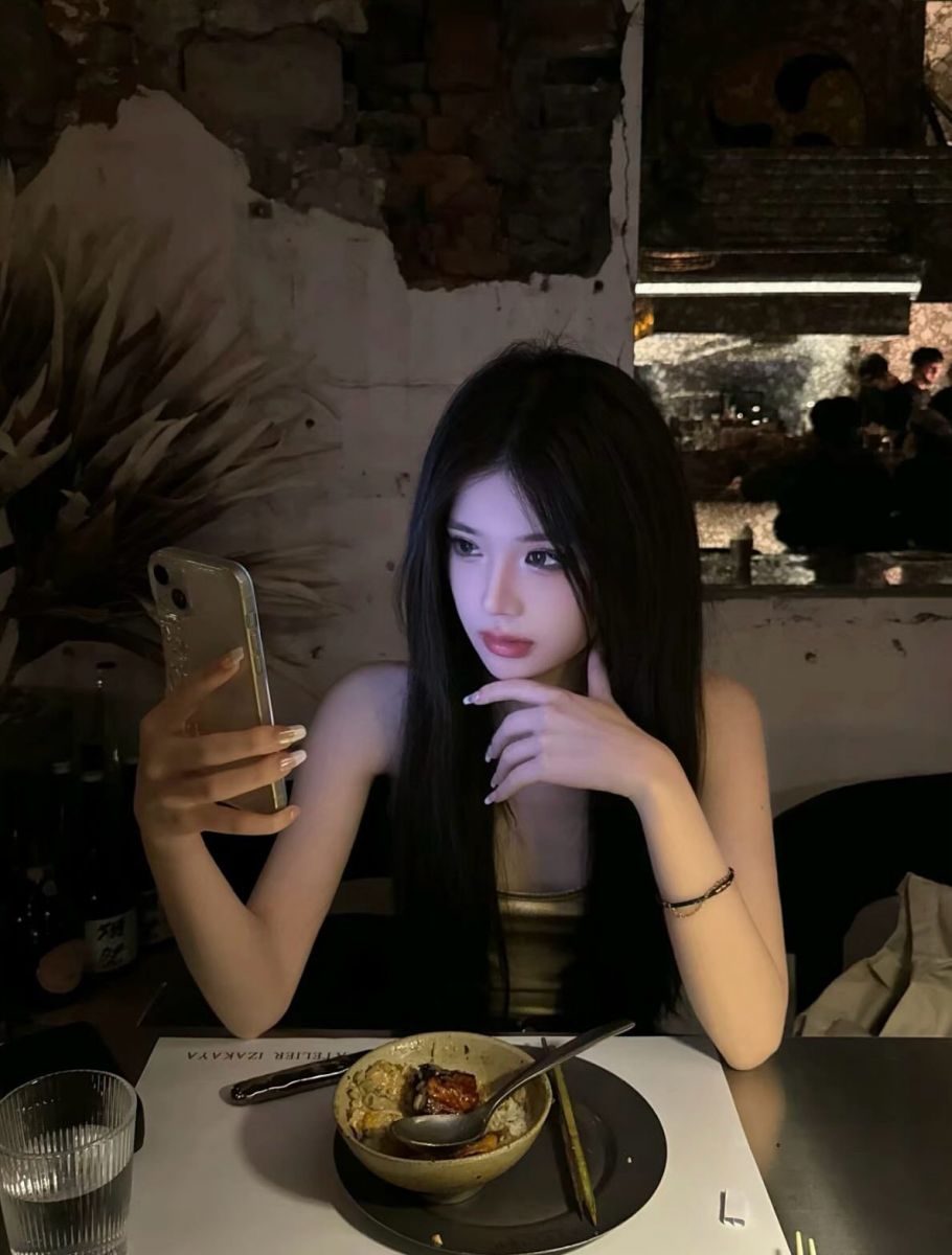 Cô gái trẻ mặc áo nịt vàng xinh đẹp chụp hình trong nhà hàng