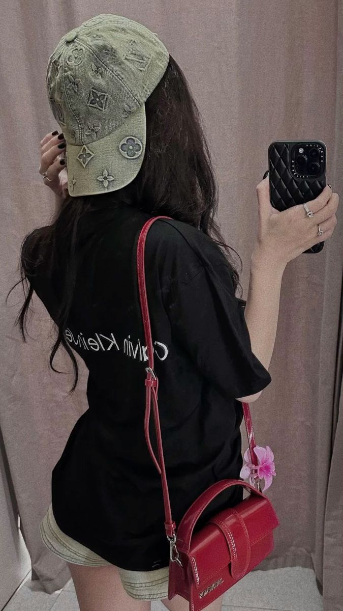 Cô gái trẻ mặc áo phông đen và quần shorts thời trang