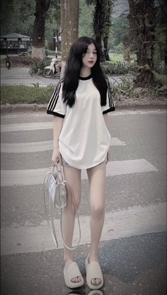 Cô gái trẻ mặc áo phông trắng và quần sooc ngắn xinh đẹp