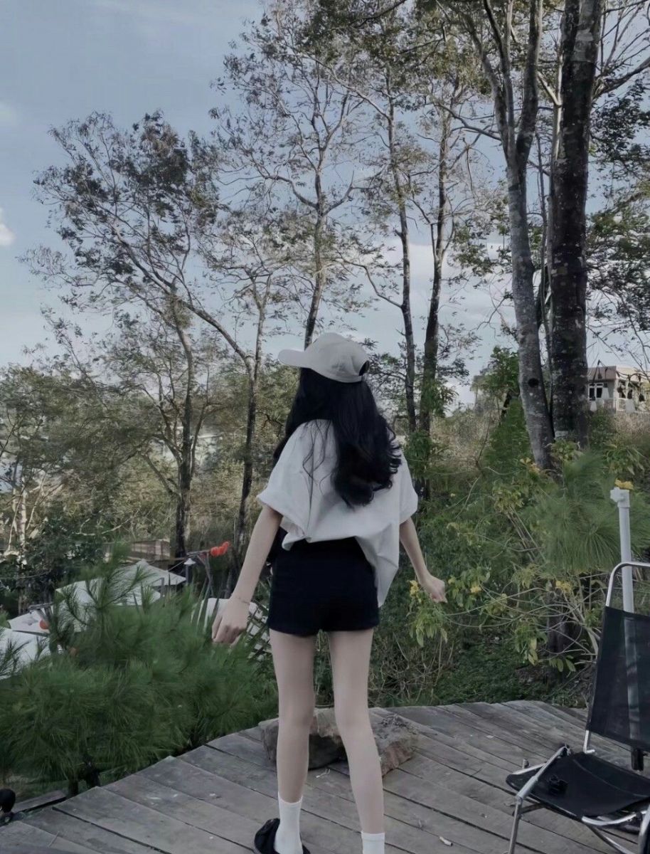 Cô gái trẻ mặc áo phông và quần shorts trong rừng